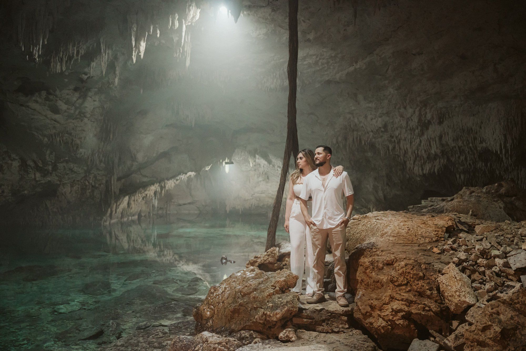 Romantic cenote proposal in Tulum with a massive floral arch reflected in the still waters of a private jungle lagoon.