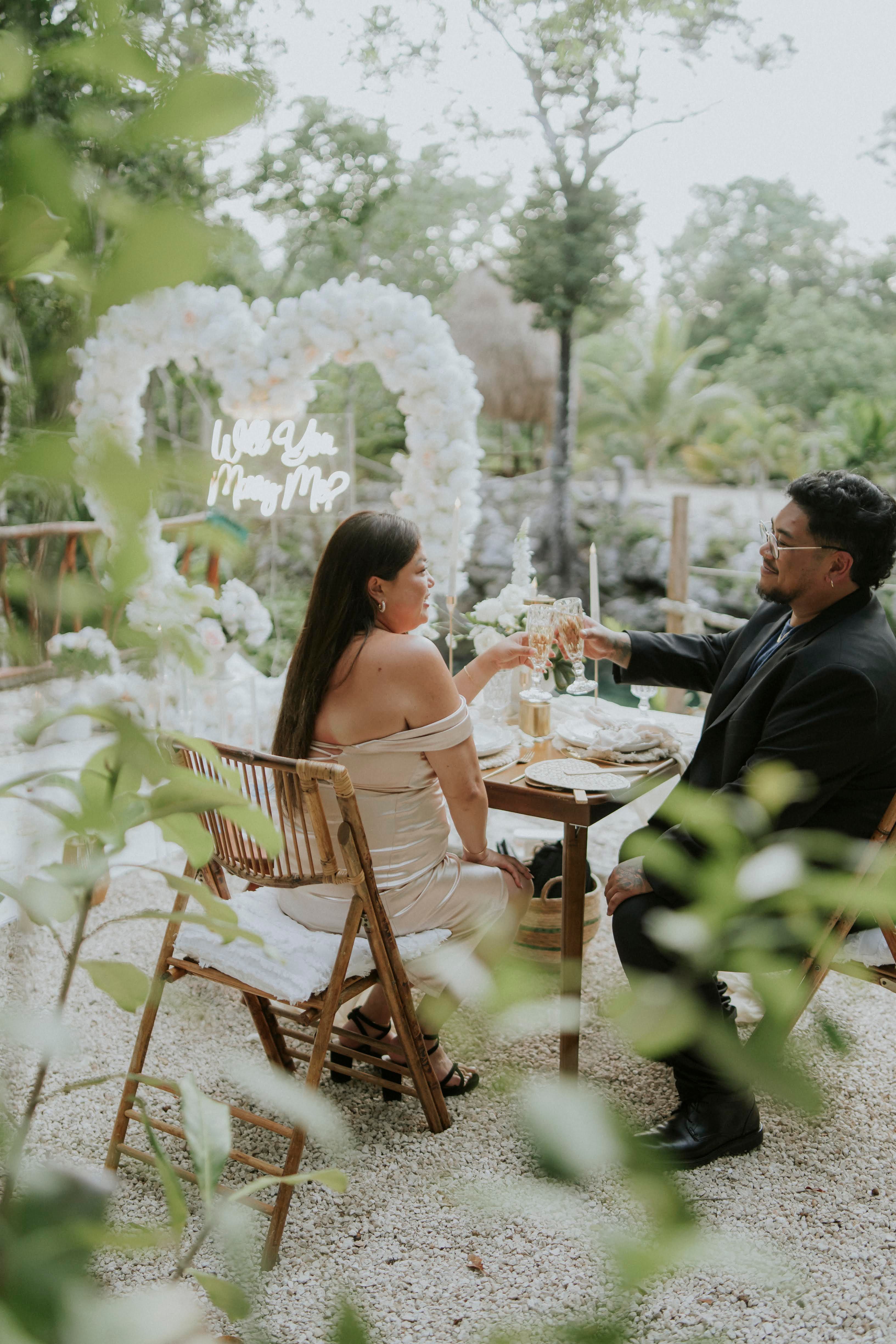 Magical cenote proposal in Tulum with soft blue lanterns and a white floral arch creating a mystic glow in the heart of the jungle.