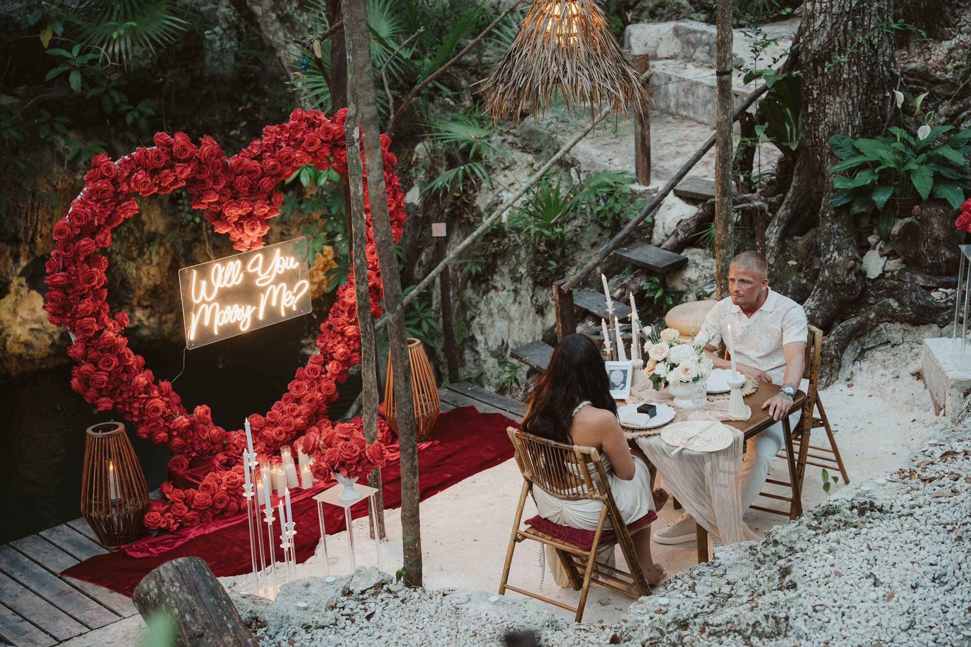 Couple embracing in a cavernous cenote in Playa del Carmen after a proposal, with the sound of dripping water echoing through the ancient space.