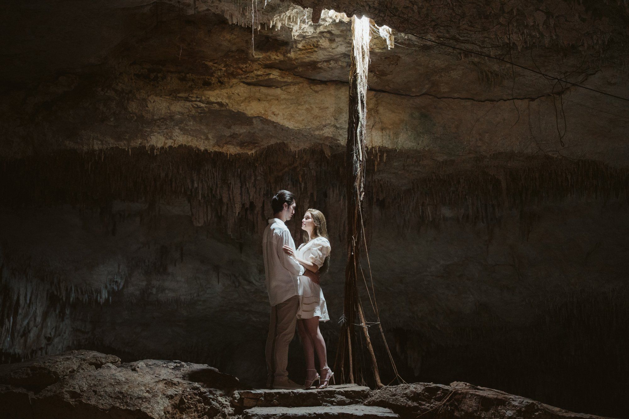 Traditional Mayan blessing ceremony integrated into a cenote proposal in Tulum, featuring local dancers and a sacred atmosphere.