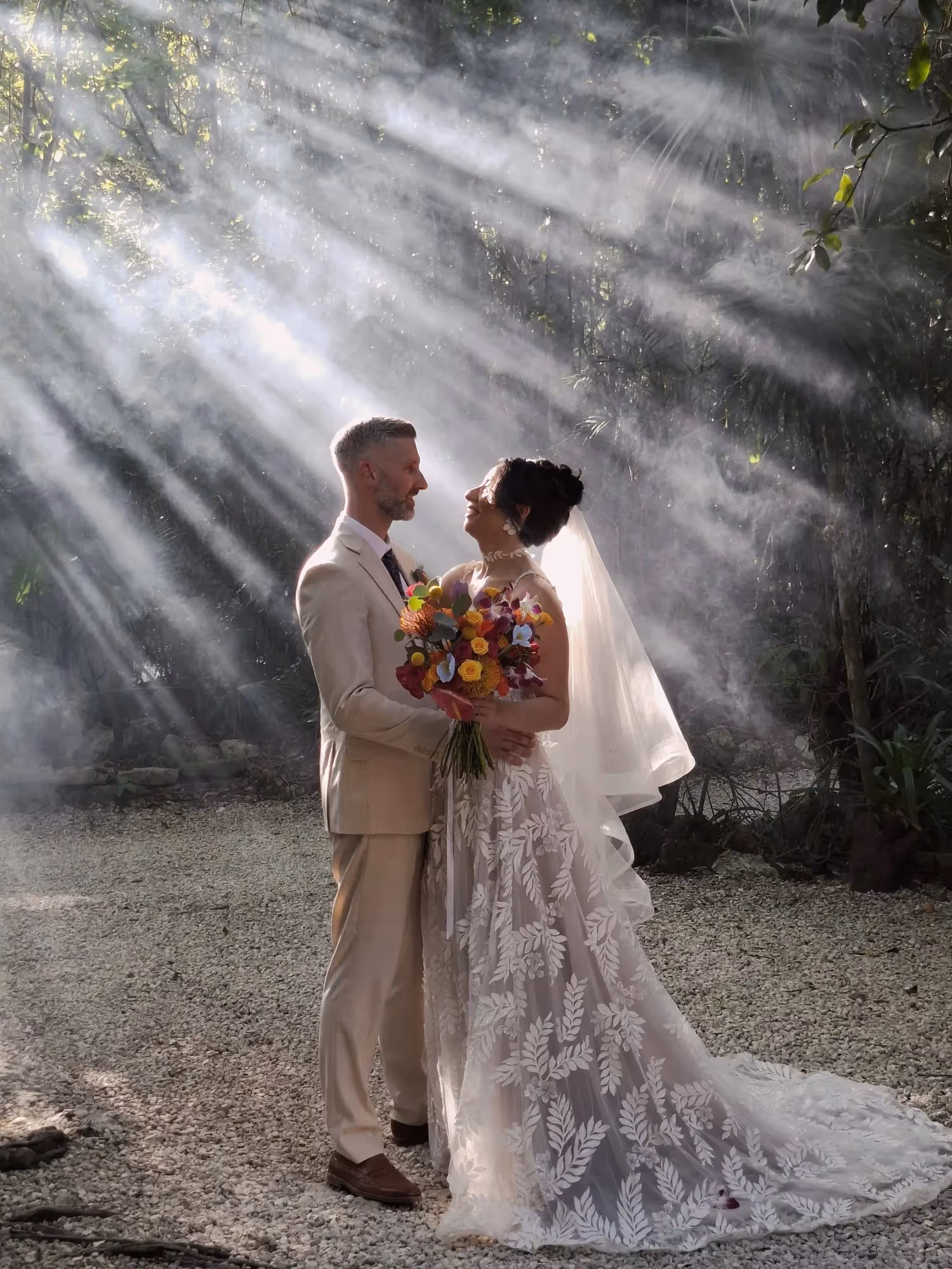 Couple during a cenote wedding beneath sunbeams