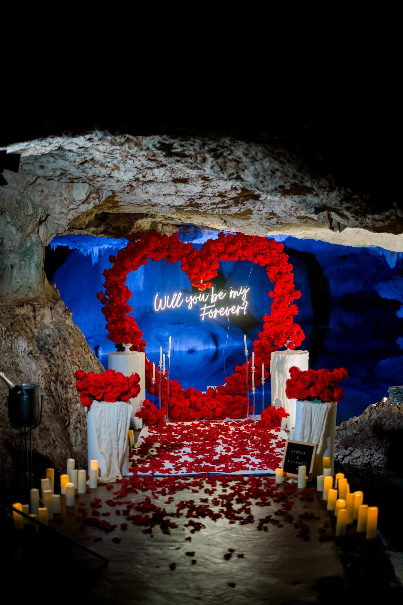 A red rose proposal setup lit by candles inside a Riviera Maya cenote cave