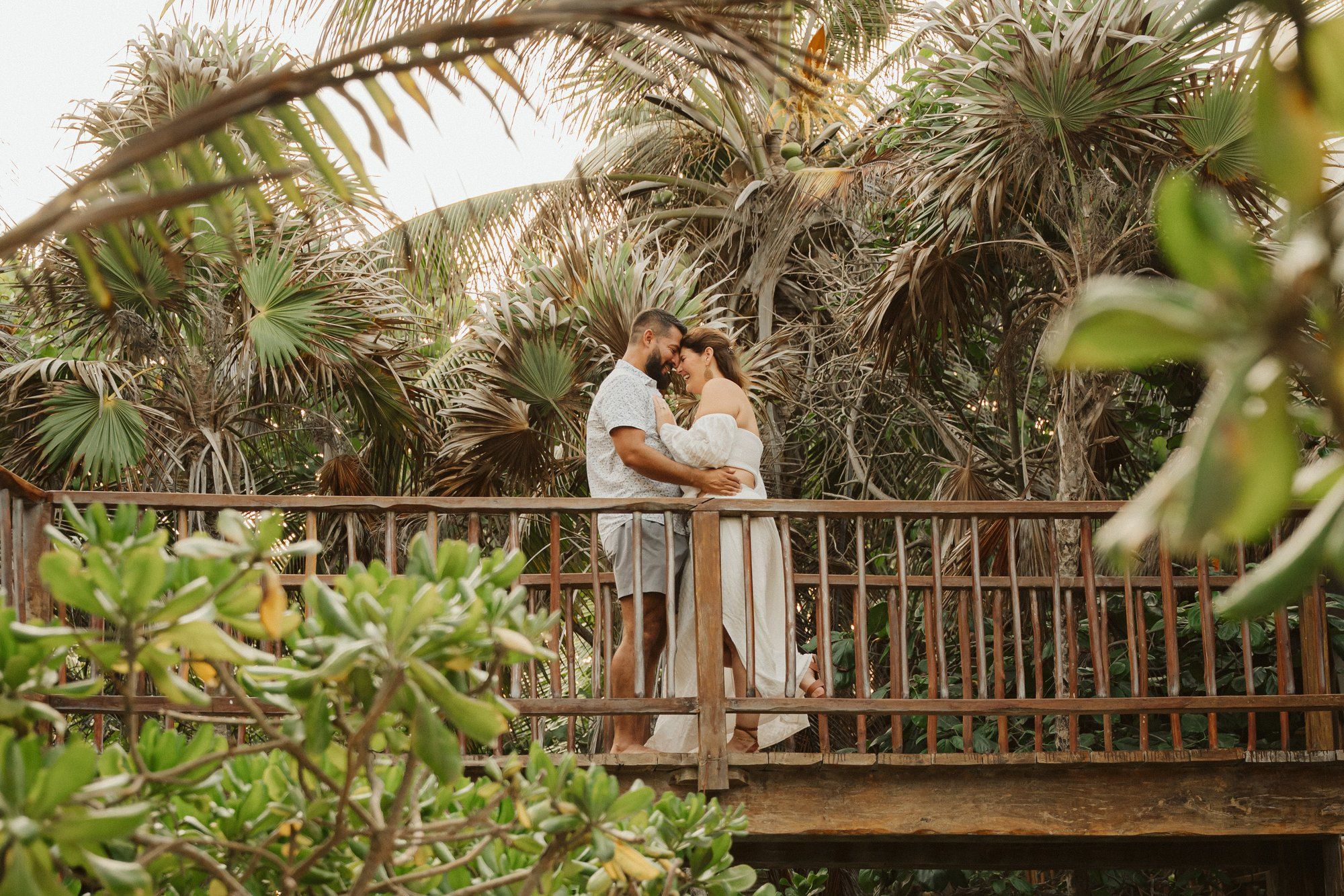 Rooftop proposal in Playa del Carmen with a massive rose heart arch and an elevated view of the ocean at twilight.