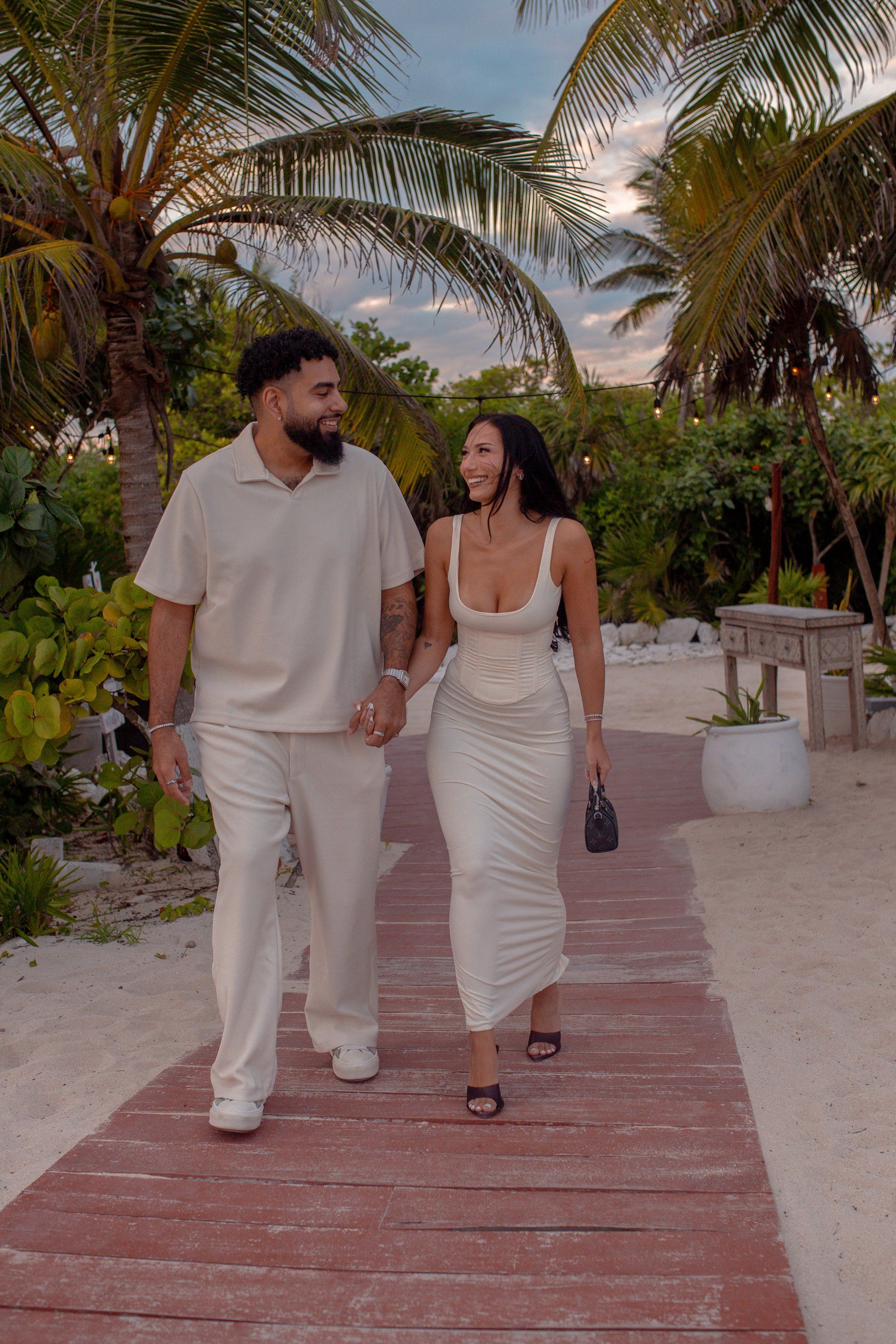 Luxury rooftop marriage proposal in Playa del Carmen featuring elaborate floral decor, tiered candles, and a stunning view of the city skyline.