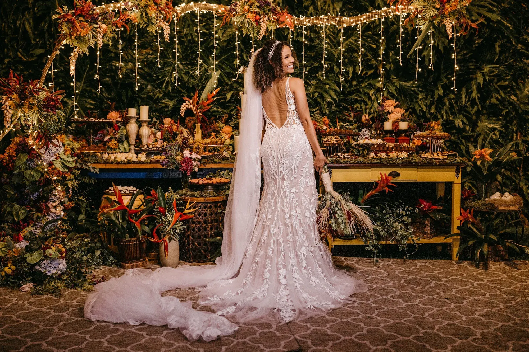 Bride beside a wedding table with vibrant floral decor